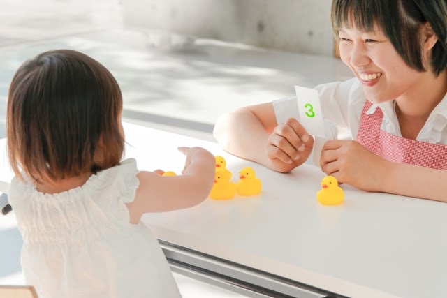 女児と遊ぶ保育士