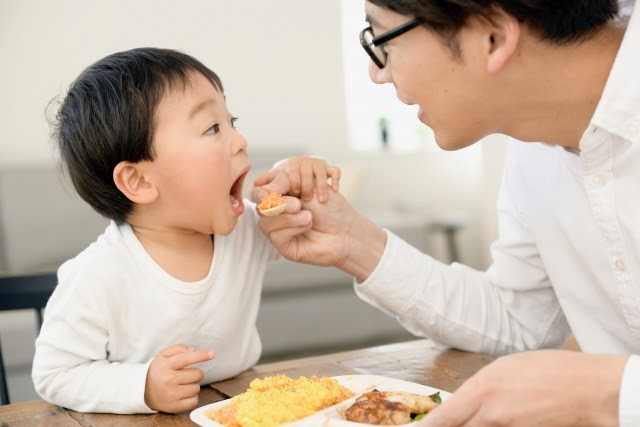 食事を子供に与えるパパ