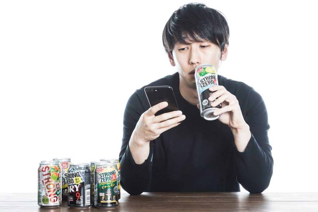 お酒を飲みながらスマホを見るお父さん