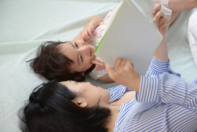 親子の読み聞かせの様子(寝転がりながら)