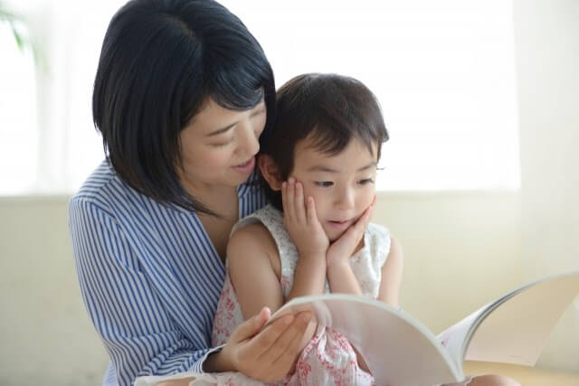 親子の読み聞かせの様子(膝に載せながら)