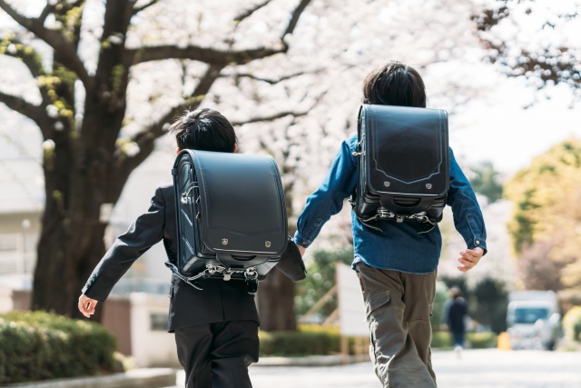 手をつないで登校するランドセルを背負った小学生