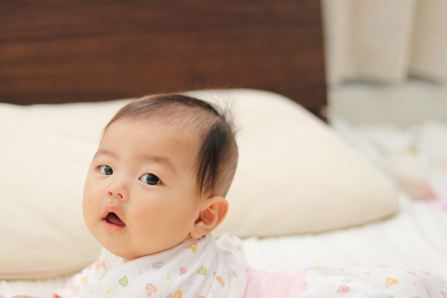 ベッドで寝転がる赤ちゃん
